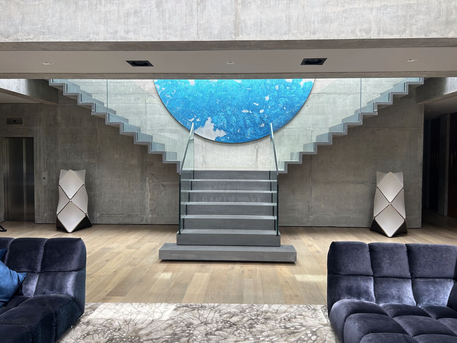 A lit floating glass staircase in a smart home installed by OLB Installations